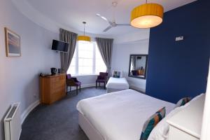 埃克斯茅斯庄园酒店的一间卧室设有一张床和蓝色的墙壁