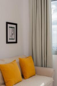 阿斯提帕莱亚镇Cozy Residence的客厅配有带黄色枕头的沙发