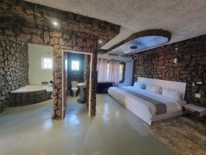 卡萨内Rustiek Hotel的一间卧室设有一张床和石墙
