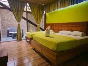 别霍港Caribbean Sea Towers Hotel的一间设有两张床的卧室,位于一个黄色墙壁的房间