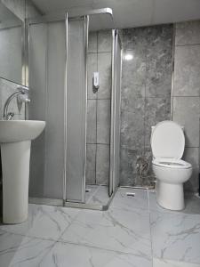 乌沙克Uyu Room Uşak Otel的带淋浴、卫生间和盥洗盆的浴室
