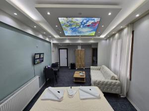 乌沙克Uyu Room Uşak Otel的客厅配有沙发和带绘画的天花板