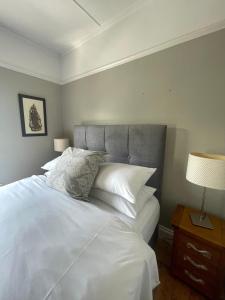 纽卡斯尔Grey Heron Townhouse的卧室配有一张带白色床单和枕头的大床。