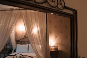 卡托劳塔翁Enastron Hotel的一间卧室配有一张带镜子的天蓬床