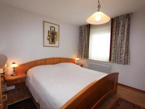 ArriachFerienwohnung Mangartblick的一间卧室设有一张大床和一个窗户。