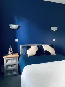 罗斯韦尔Blue Bell的一间蓝色卧室,配有床和床头柜