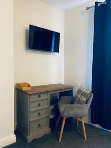 罗斯韦尔Blue Bell的一张桌子、椅子和墙上的电视
