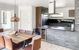 托弗塔3 Bedroom Cozy Home In Gotlands Tofta的厨房以及带木桌和椅子的用餐室。