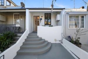 悉尼Balmain Central Cozy 3 bed house的白色的房子,设有通往前门的楼梯