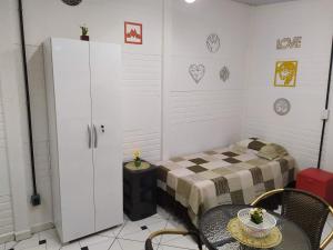 阿蒂巴亚Condomínio Dona Cida - Flats, Casas e kitnets Mobiliadas的配有一张床和一张桌子及椅子的房间