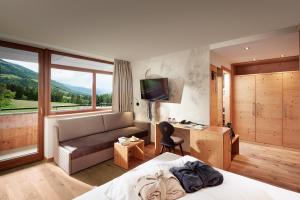 崔聂斯第瓦尔自然酒店的酒店客房配有床、沙发和电视。