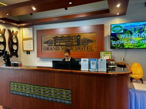 巴纳韦Banaue Grandview Hotel的坐在一家宏伟酒店酒吧里的人