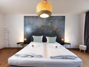 伊尔梅瑙BohnApartments - Design Suiten Am Markt - Vollausstattung - WLAN - Zentrum - Vollausstattung的卧室配有一张带两张桌子的大型白色床