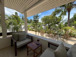 苏梅岛Moorea Boutique Resort Samui的享有海滩和棕榈树景致的客厅