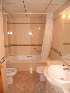 萨洛萨鲁帕拉斯公寓的带浴缸、卫生间和盥洗盆的浴室