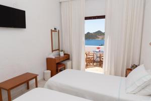 帕特莫斯Golden Sun Hotel Patmos的酒店客房设有两张床,享有海景。