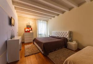 贝加莫贝加莫贵宾公寓的一间卧室配有一张床、一个梳妆台和一扇窗户。