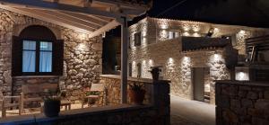 阿里奥波利斯Sophia Town Square Areopoli的一座石头建筑,晚上有灯