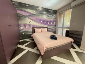 索非亚Spacious apartment in the heart of Studentski grad的一间卧室配有一张床和紫色的墙壁