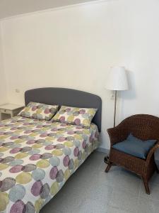 乌尔比诺Il Glicine - Monolocale a due passi dal centro的一间卧室配有一张床、一把椅子和一盏灯