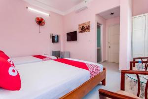 岘港Motel Tulip的一间卧室配有两张红色和白色床单