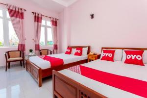 岘港Motel Tulip的一间卧室配有两张带红白色枕头的床