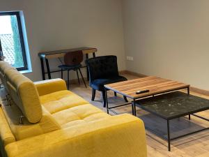 雷涅斯Au Petit Bonheur chez Bambina的客厅配有黄色的沙发和桌子