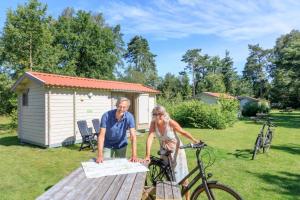 阿珀尔斯哈RCN Vakantiepark de Roggeberg的男人和女人站在桌子上,骑着自行车