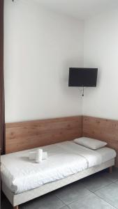 巴斯蒂亚里维埃拉酒店的卧室配有一张床铺,墙上配有电视
