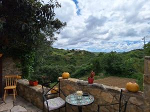 马夫拉Casa das Janelinhas - Cottage near Sintra, Mafra, Ericeira的石墙上配有桌椅的庭院