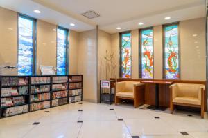名古屋名古屋金山名铁旅馆的一个带椅子和彩色玻璃窗的图书馆