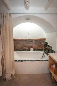 圣安东尼奥ES CUCONS RURAL HOTEL的带浴缸和淋浴帘的浴室