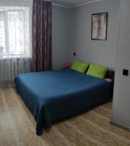 克列缅丘格Smart Apartment на Соборной 23的一间卧室设有蓝色的床和窗户。