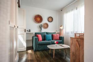 圣安东尼奥ES CUCONS RURAL HOTEL的客厅配有绿色沙发和桌子