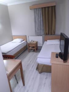埃尔祖鲁姆OTEL AMİLLER的客房设有两张床和一台平面电视。