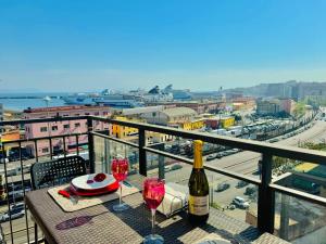 那不勒斯Napoli Centro的阳台上的桌子和两杯葡萄酒
