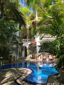 康提Villa Olde Ceylon的棕榈树建筑庭院中的游泳池