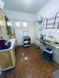 伊斯梅利亚شقق وشاليهات بمدينة النورس的厨房铺有棕色瓷砖地板,配有水槽