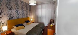丰沙尔Vila Calaça的配有蓝色枕头的床的酒店客房