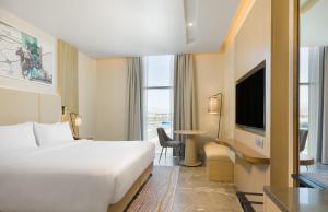 马斯喀特IntercityHotel Bawshar Muscat的酒店客房,配有床和电视