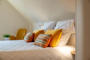 达默Hoeve den Akker - luxueuze vakantiewoningen met privétuinen en alpaca's nabij Brugge, Damme, Knokke, Sluis en Cadzand的一张黄色和白色枕头的床