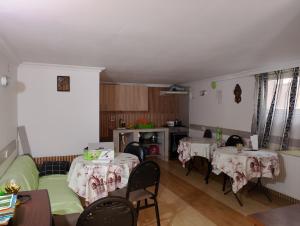 巴统Jessi Batumi的客厅配有2张桌子和1张长沙发和椅子