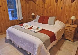 圣马丁德洛斯Apart Hotel Orilla Mansa by Visionnaire的一间卧室配有带毛巾的床