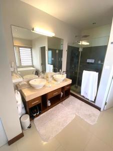 埃斯尼角Sablexotique的一间带两个盥洗盆和大镜子的浴室