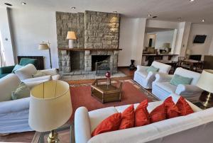 圣马丁德洛斯Hotel Caupolican by Visionnaire的客厅配有白色沙发和石制壁炉