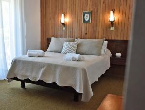 圣马丁德洛斯Hostería Cerro Nevado by Visionnaire的一间卧室配有一张床,上面有两条毛巾