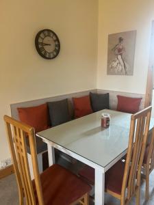 克利夫登Racecourse Lodge Apartment的一张桌子和椅子,配有沙发和时钟