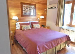 圣马丁德洛斯Cabañas Las Pampas by Visionnaire的一间卧室配有一张大床和两个枕头