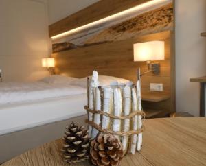 卡兰茨奥赫霍恩酒店的一间卧室配有一张床和一张带松锥的桌子。