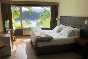 拉安戈斯图拉镇Puerto Manzano Suites by Visionnaire的一间卧室设有一张大床和大窗户